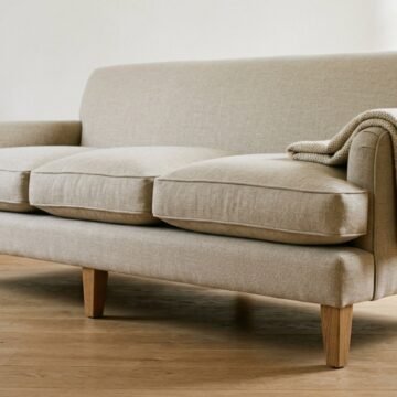 Close-up of a well-made linen sofa showing deep seat cushions and solid wooden legs